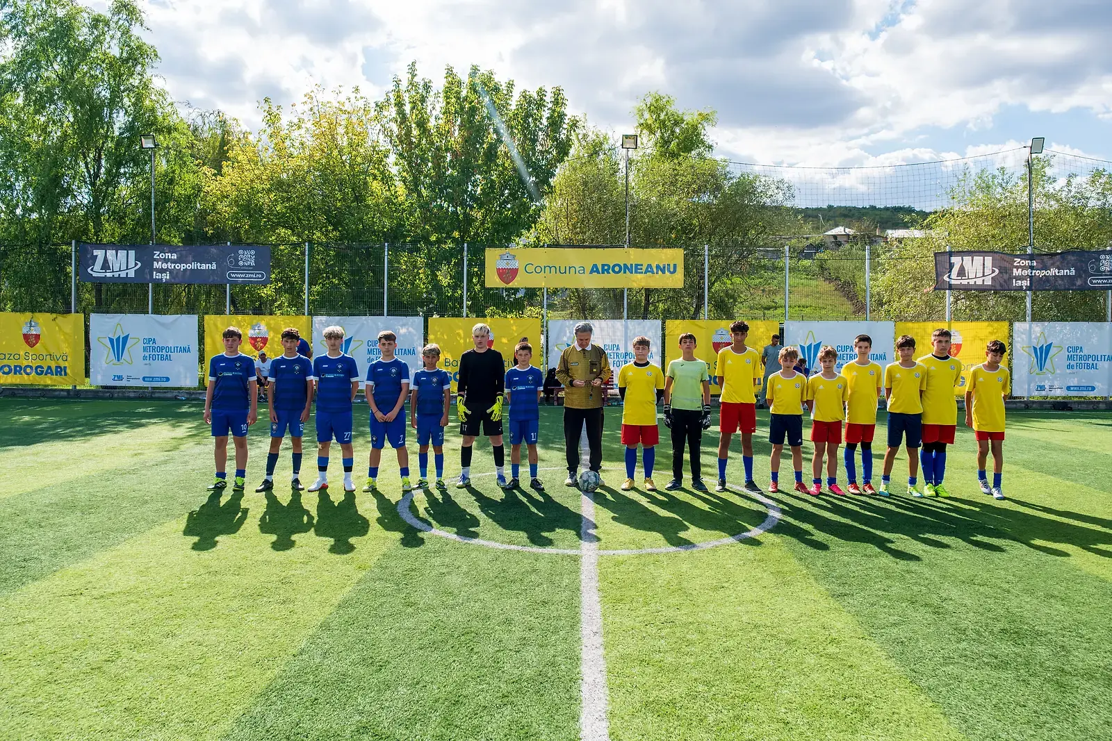 Echipele aliniate la centrul terenului înaintea unui meci de la Cupa Metropolitană de Fotbal